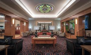 a lobby with a table and chairs and a stained glass window at Riu Plaza The Gresham Dublin in Dublin