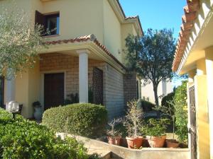 a house with potted plants in front of it at Sardinia B&B house in Olbia