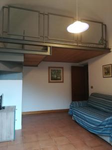 Habitación con cama y techo con luz. en Monolocale in villa, en Castiglioncello