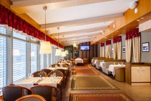 a dining room with tables and chairs and windows at Hotell Wironia in Jõhvi