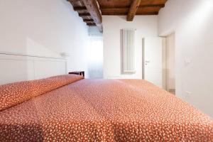 フィレンツェにあるcasa tradizionale toscanaの白い部屋の大きなオレンジ色のベッド