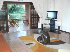 a living room with a television and a dog statue at Country Link Guest Lodge in Komatipoort