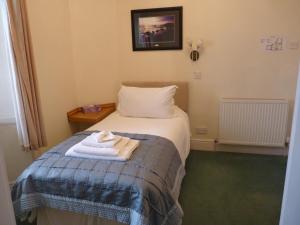 a hotel room with a bed with towels on it at Pentland Lodge House in Thurso