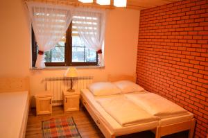 a bedroom with a bed and a brick wall at Domek pod Majową Górą in Kacwin