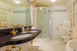 a bathroom with two sinks and a shower at Hotel Funggashof in Naturno