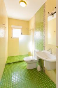オリーバにあるLlebeig 2の緑のタイル張りのバスルーム(洗面台、トイレ付)