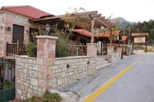 a building with a stone wall next to a street at Guesthouse Kastania Korakis in Kastania