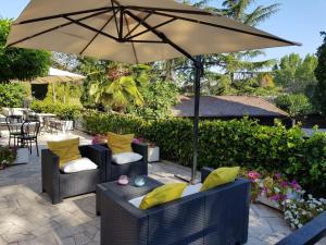 a patio with two chairs and an umbrella at Hotel Boomerang Roma in La Massimina-Casal Lumbroso