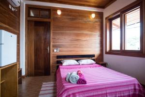 1 dormitorio con 1 cama con manta rosa en Albergaria Porcelana, en São Tomé