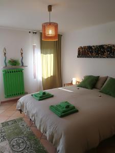 Colognola ai ColliにあるB&B Ponteselloのベッドルーム1室(大型ベッド1台、緑のタオル付)