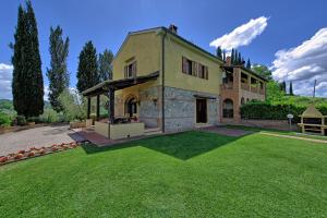 una grande casa con un prato davanti di Villa Sabrina by PosarelliVillas a San Gimignano