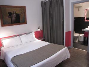 a bedroom with a white bed and a bathroom at Trastevere Colors in Rome