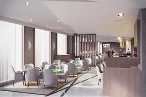 a restaurant with white chairs and tables and a bar at Maldron Hotel Kevin Street, Dublin City in Dublin
