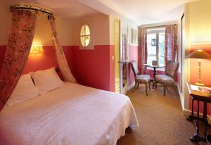 a bedroom with a bed and a table and chairs at Hotel Restaurant des Deux Rocs in Seillans