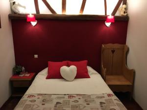 a bedroom with a bed with red walls and a heart pillow at Ferme Des Chartroux in Maresville