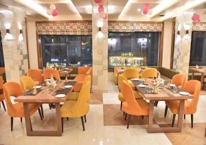 two pictures of a restaurant with tables and chairs at Hotel Rk Grand in Varanasi