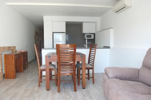 sala de estar con mesa, sillas y sofá en Apartament Cortey en Calella de Palafrugell