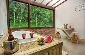 a bathroom with a bath tub and a large window at Pousada Valle do Avencal 5 Km do Centro in Urubici