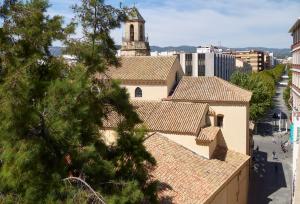 - une vue sur les toits d'un immeuble avec une tour dans l'établissement Casual Suite in Córdoba, à Cordoue