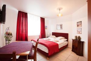 a bedroom with a bed and a table and a window at Pension Jasmin in Pforzheim