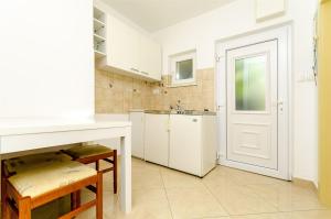 a kitchen with white cabinets and a white door at Apartments Vinko in Trogir +39 photos