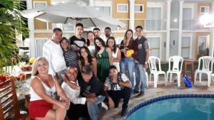 un grupo de personas posando junto a una piscina en apartamento monte hebron, en Porto Seguro