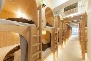 eine Reihe von Etagenbetten in einem Schlafsaal in der Unterkunft &AND HOSTEL AKIHABARA in Tokio