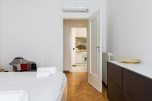 ミラノにあるCanguroProperties - Volterraの白いベッドルーム(ベッド1台付)、キッチンが備わります。