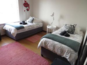 a bedroom with two beds and a red rug at Spoil Yourself in Swakopmund