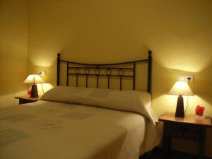 a bedroom with a large white bed with two lamps at El Salat, alojamientos rurales in Guadalest
