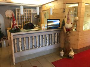 a restaurant with a christmas store with a counter at Alpenlife Hotel Someda in Moena