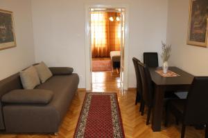 a living room with a couch and a dining room table at Apartment Centrum in Novi Sad