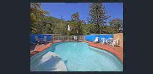 einen kleinen Pool mit Stühlen und einer Terrasse in der Unterkunft Koala Cove Holiday Apartments in Gold Coast