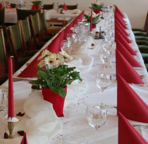 een lange tafel met wijnglazen en bloemen erop bij Hotel Haus Koppelberg in Wipperfürth