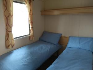 two beds in a small room with a window at Newquay View Hideaway in Newquay