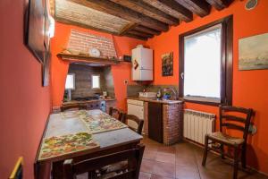 a kitchen with orange walls and a table and a window at between the channels, in San Marco in Venice