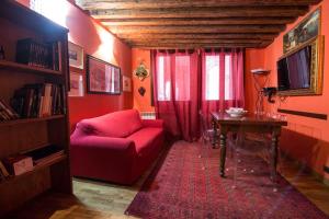 ein Wohnzimmer mit einem roten Sofa und einem Tisch in der Unterkunft between the channels, in San Marco in Venedig