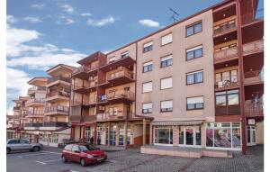 aartment building with a red car parked in a parking lot at Apartman Mira in Daruvar