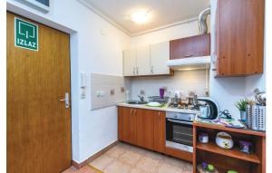 a kitchen with wooden cabinets and a door in a room at Apartman Mira in Daruvar