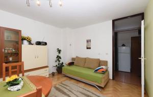 a living room with a green couch and a table at Apartman Mira in Daruvar