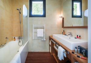 a bathroom with a tub and a sink and a bath tubermottermott at Center Parcs Les Bois Francs in Verneuil d'Avre et d'Iton