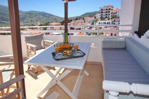 a table with a tray of food on a balcony at Kamara House in Skopelos Town