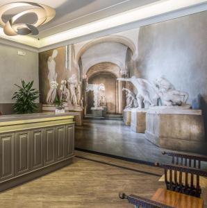 una camera con un dipinto sul muro con sculture di Hotel Museum a Roma