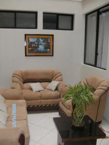 a living room with two brown couches and a table at Hostal Fevilamir in Ibarra