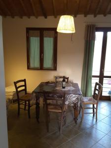 a dining room with a table with chairs and a lamp at La Steccaia in Riparbella