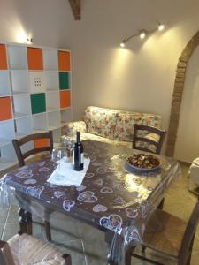 a table with a couch and a table with wine glasses at La Steccaia in Riparbella