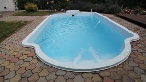 a large pool with blue water in a backyard at Holiday Apartment Krumpendorf in Krumpendorf am Wörthersee