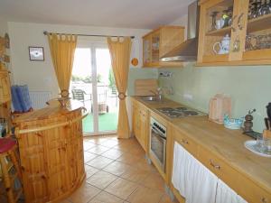 a kitchen with wooden cabinets and a stove top oven at Holiday Apartment Krumpendorf in Krumpendorf am Wörthersee