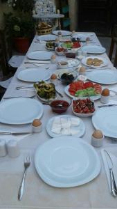 a long table with white plates and bowls of food at Urgup Konak Hotel in Ürgüp