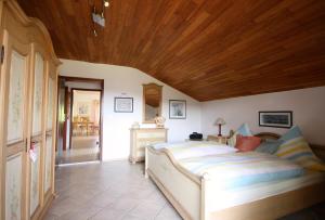 ein Schlafzimmer mit einem Bett und einer Holzdecke in der Unterkunft Ferienhaus und Ferienwohnungen Holzapfel Geiersthal in Geiersthal